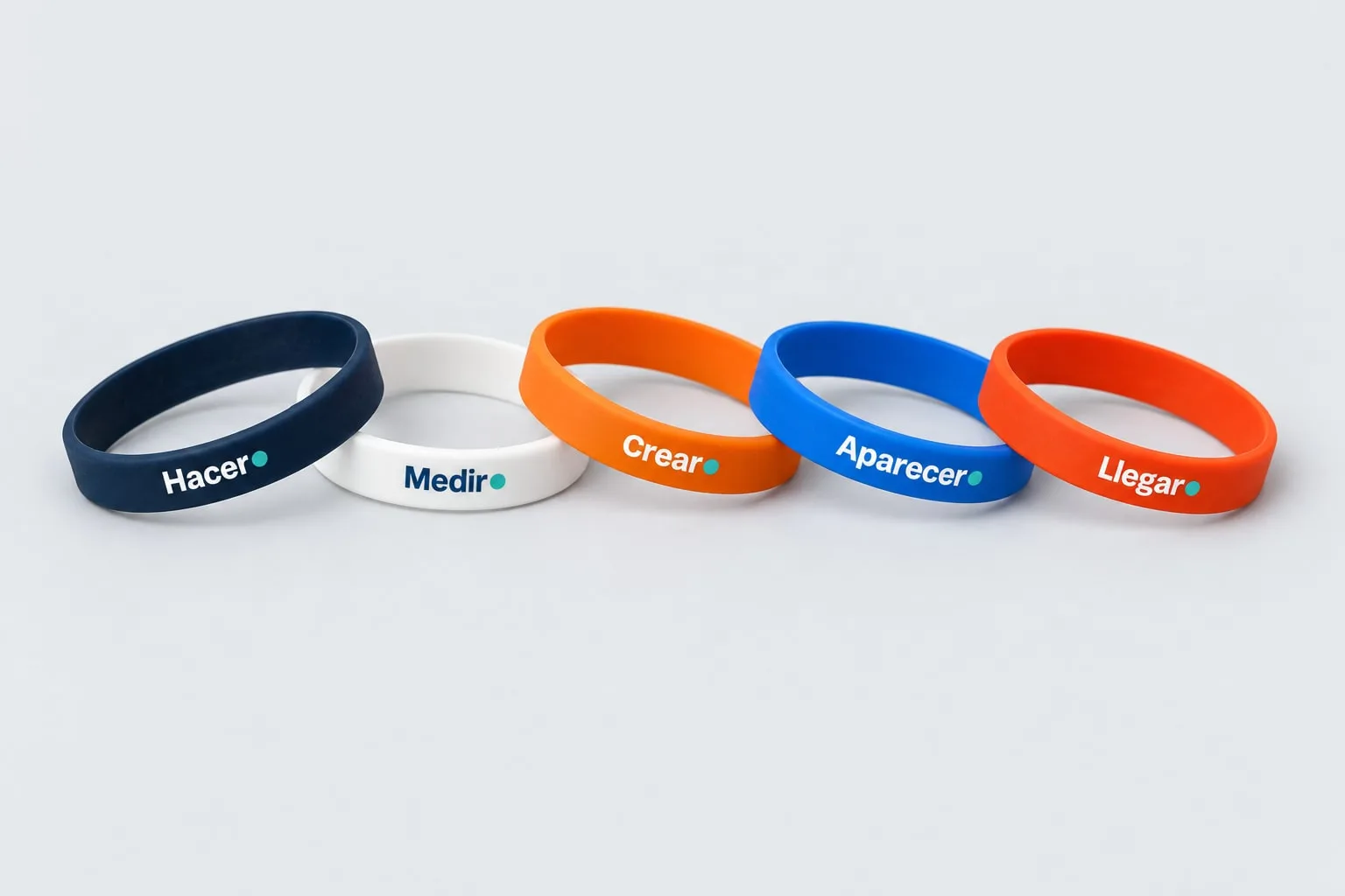 Pulseras de silicona · un verbo por pulsera: maqueta fotográfica generada con IA